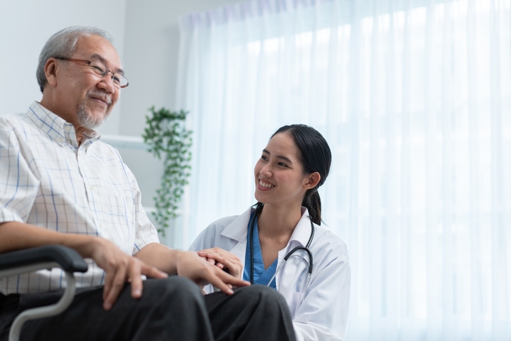 Asian,Female,Doctor,Telling,Funny,Story,To,Senior,Man,Sitting